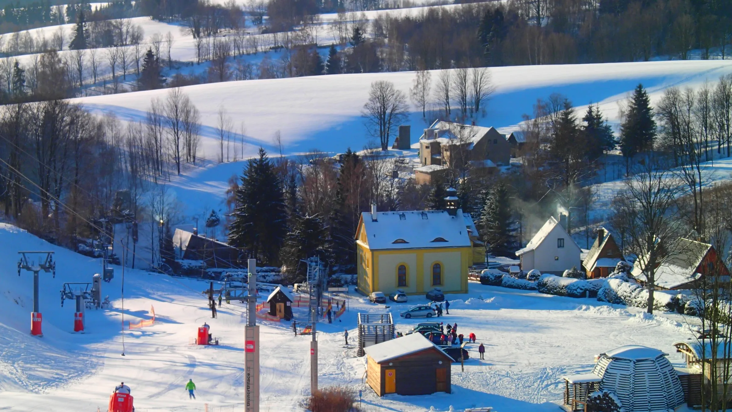 Verschneites Hynčice pod Sušinou mit dem Penzion Pod Zvonem und einer Skipiste