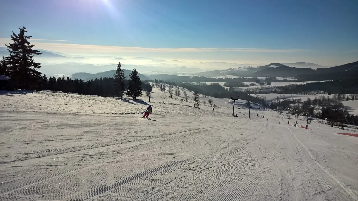 Snowboarder on the slope with a view over the countryside
